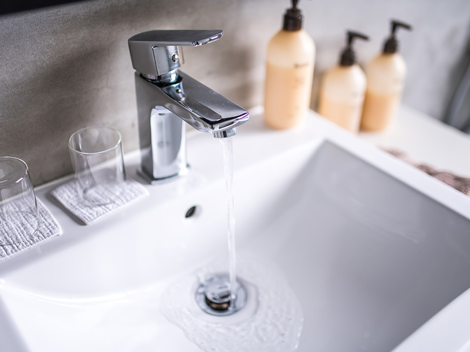 Bathroom faucet turned on with water going down the drain